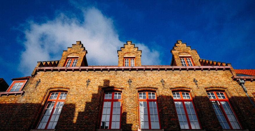 low-angle-shot-of-a-brown-bricked-made-cathedral-with-windows-at-daytime_181624-2118