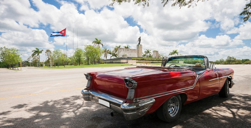 classic-convertible-car-with-monument-and-cuban-flag-in-background_23-2148226498